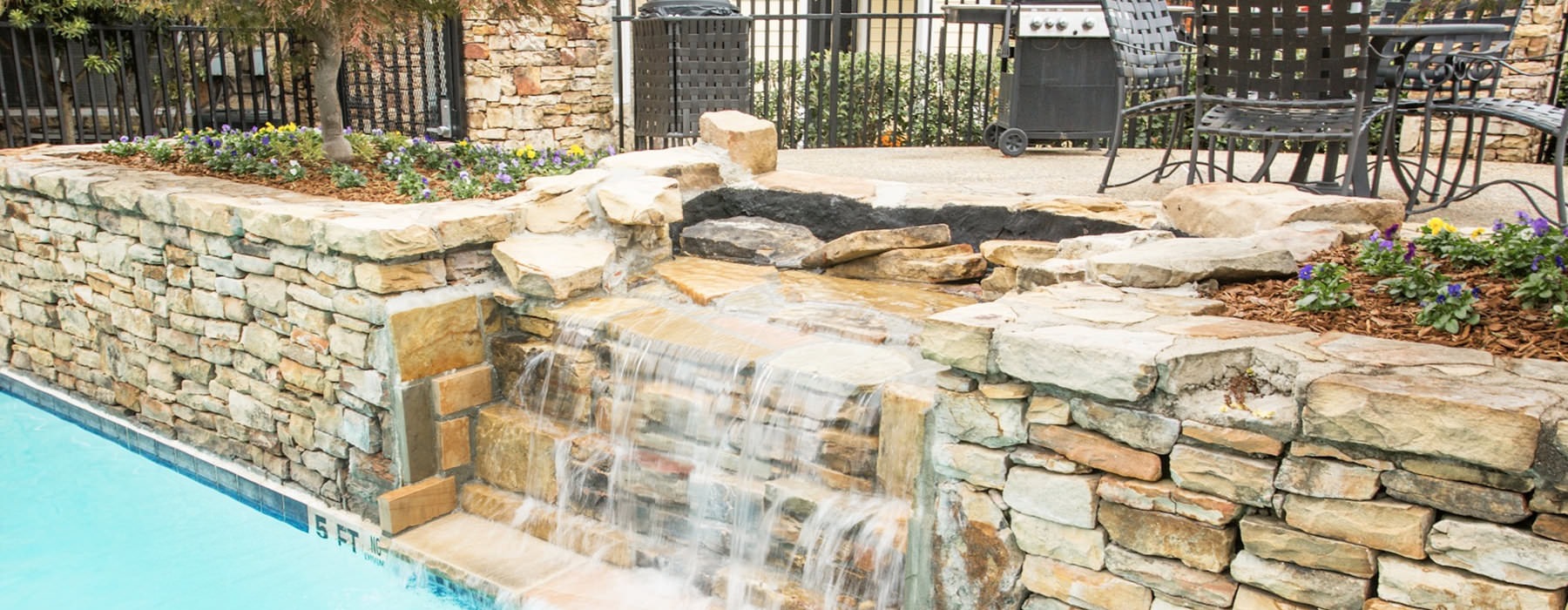 stone waterfall feature at pool